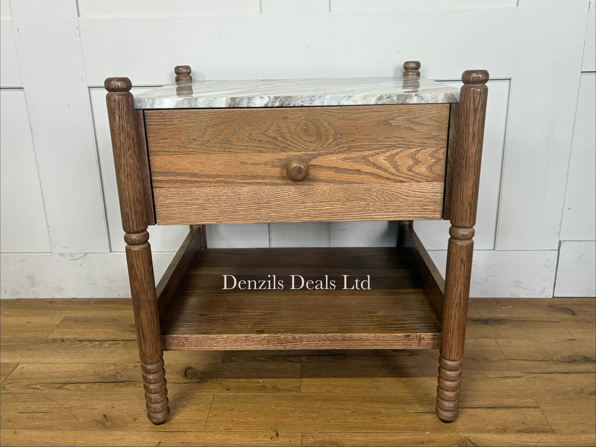 The Amelia Marble-Top Nightstand by Anthropologie features a smooth Toronto marble top, delicate spindled legs, an undermount shelf, and crafted oak woodgrain detailing.
