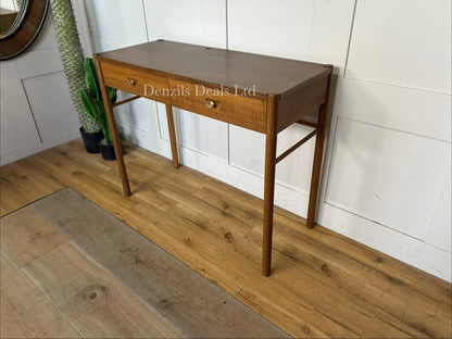Anthropologie Bernadette Makeup Vanity crafted from solid oak with two drawers, and brass accents against a neutral wall
