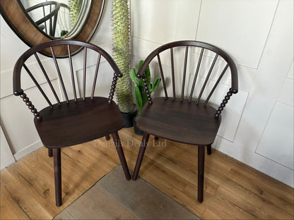 Anthropologie Bobbin Spindle Wood Dining Chair in neutral finish from a front view, showcasing ornamental turned spindles on the legs, backrest, and side rails