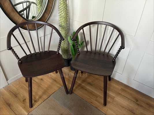 Anthropologie Bobbin Spindle Wood Dining Chair in neutral finish from a front view, showcasing ornamental turned spindles on the legs, backrest, and side rails