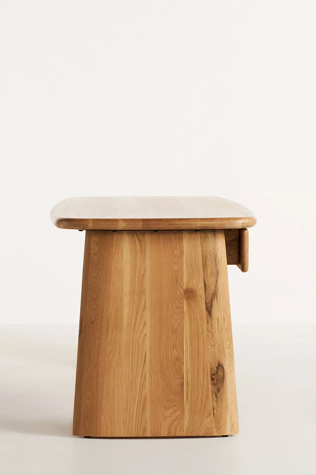 Anthropologie Kalle Sculptural Desk with natural oak wood grain and thick, rounded plank legs.