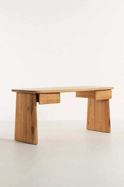 Anthropologie Kalle Sculptural Desk with natural oak wood grain and thick, rounded plank legs.