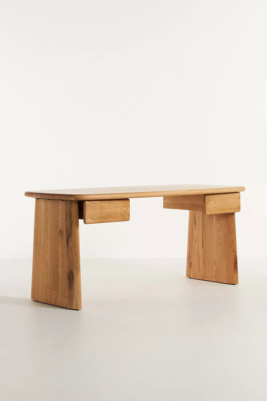 Anthropologie Kalle Sculptural Desk with natural oak wood grain and thick, rounded plank legs.