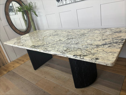 Anthropologie Renata dining table featuring a smooth marble top and rustic wooden fluted legs