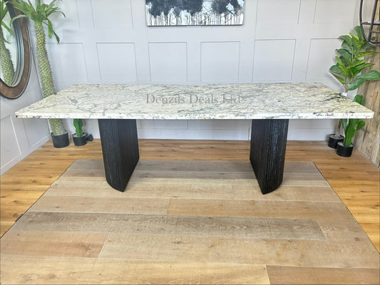 Anthropologie Renata rectangular dining table featuring a smooth white marble top and rustic wooden legs with smooth, rounded details."