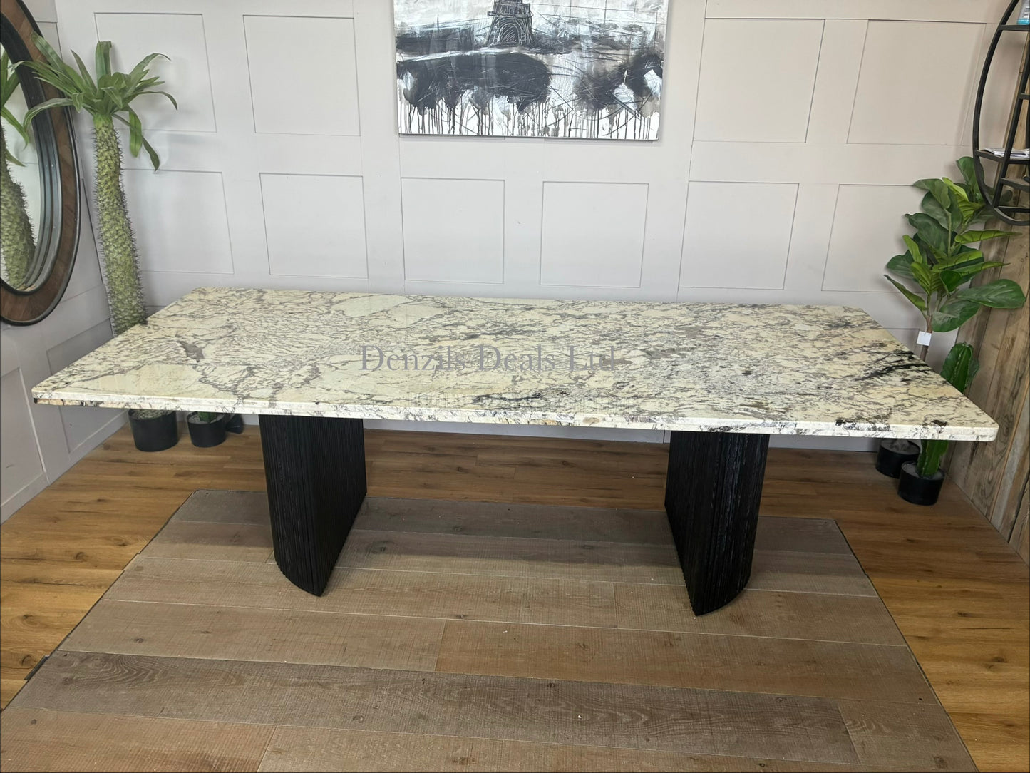 Anthropologie Renata rectangular dining table featuring a smooth white marble top and rustic wooden legs with smooth, rounded details."