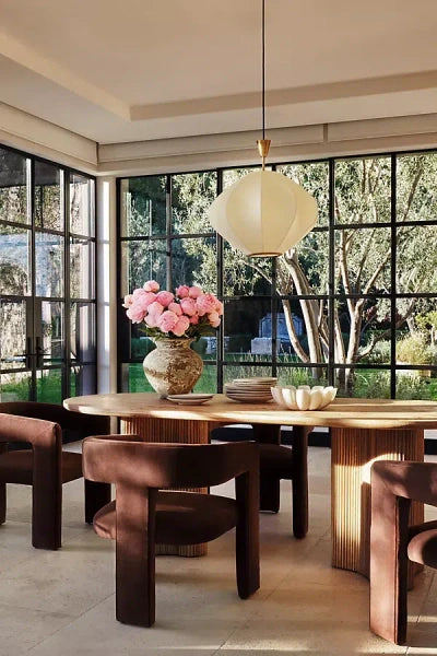 Anthropologie Scout dining table in light ash wood, featuring a decorative veneer top and a chunky, fluted base."
