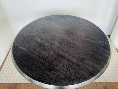 Anthropologie's black oak Iris dining table styled in a modern dining room,