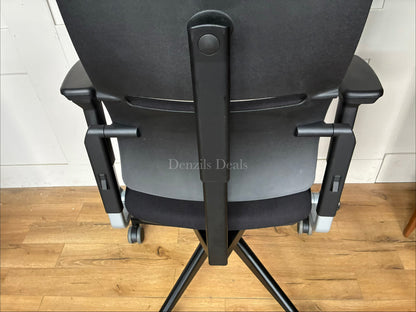 Black Steelcase Please ergonomic desk chair with a headrest.