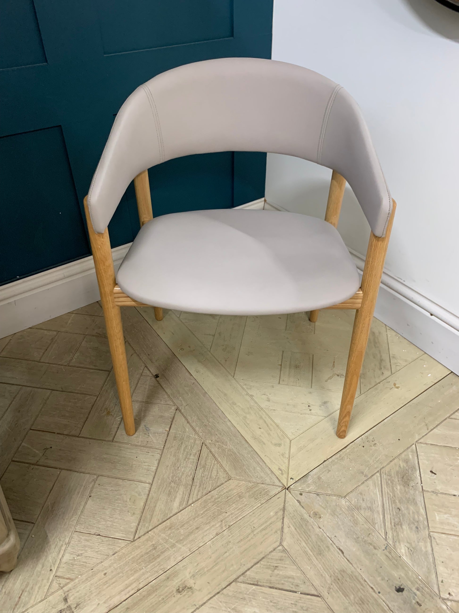 Contemporary dining armchair with a solid beechwood frame and soft, rounded upholstered backrest and seat