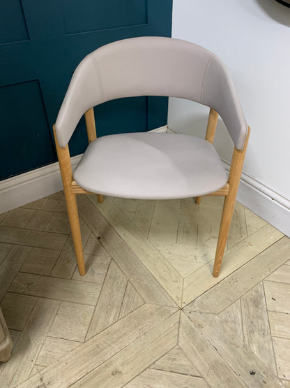 Contemporary dining armchair with a solid beechwood frame and soft, rounded upholstered backrest and seat