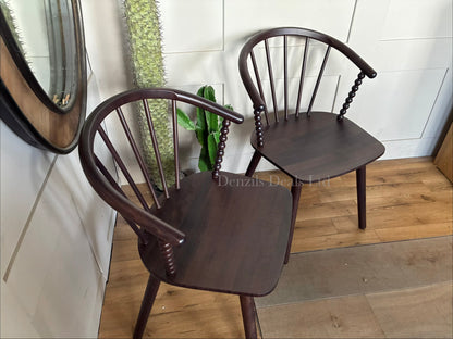Close-up of the Anthropologie Bobbin Spindle Chair, emphasizing the intricate, hand-carved turned-wood craftsmanship and light wood texture."