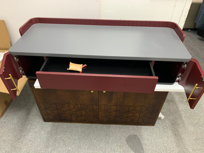 Close-up of the Lali wide desk showing polished brass handles on a matte mahogany red drawer