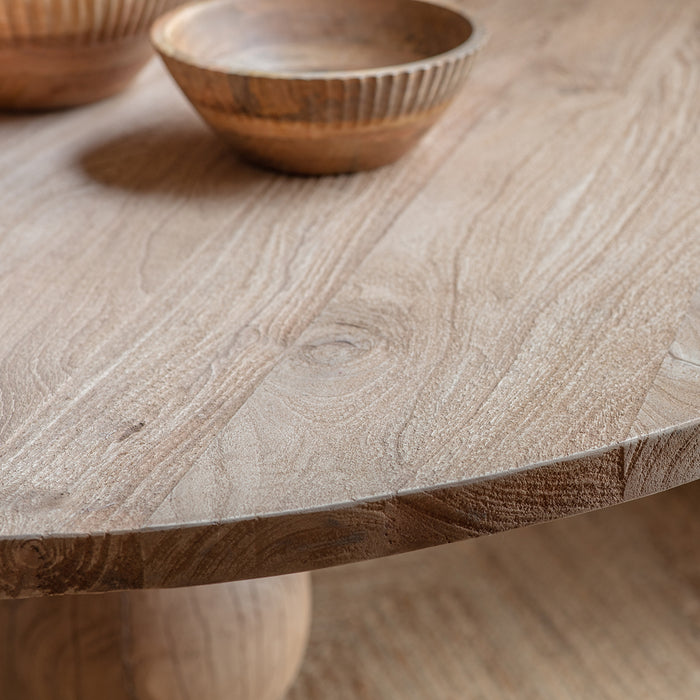 Close-up of the Nkuku Laya table surface showing the natural blonde and beige grain patterns of sustainable mango wood with a smooth, matte finish."