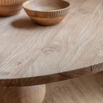Close-up of the Nkuku Laya table surface showing the natural blonde and beige grain patterns of sustainable mango wood with a smooth, matte finish."