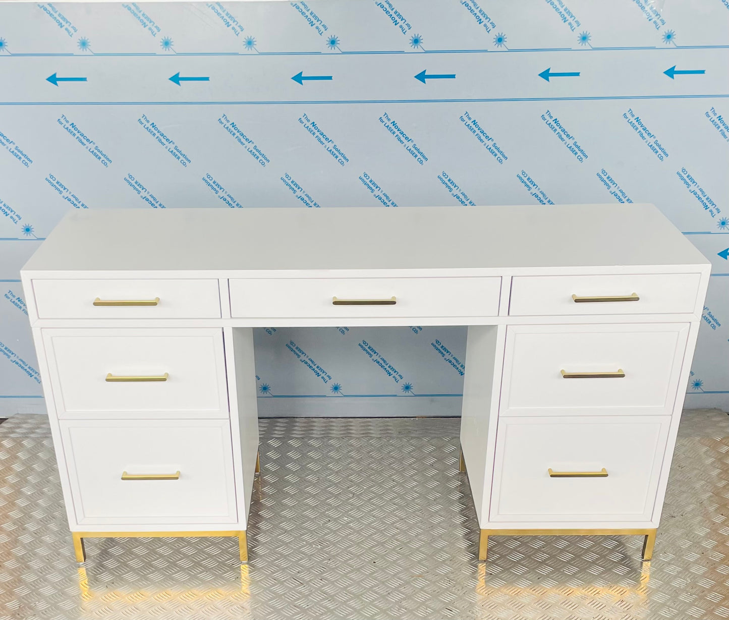 Close-up of the Blaire smart storage desk, highlighting smooth white wood finish and metallic gold hardware."
