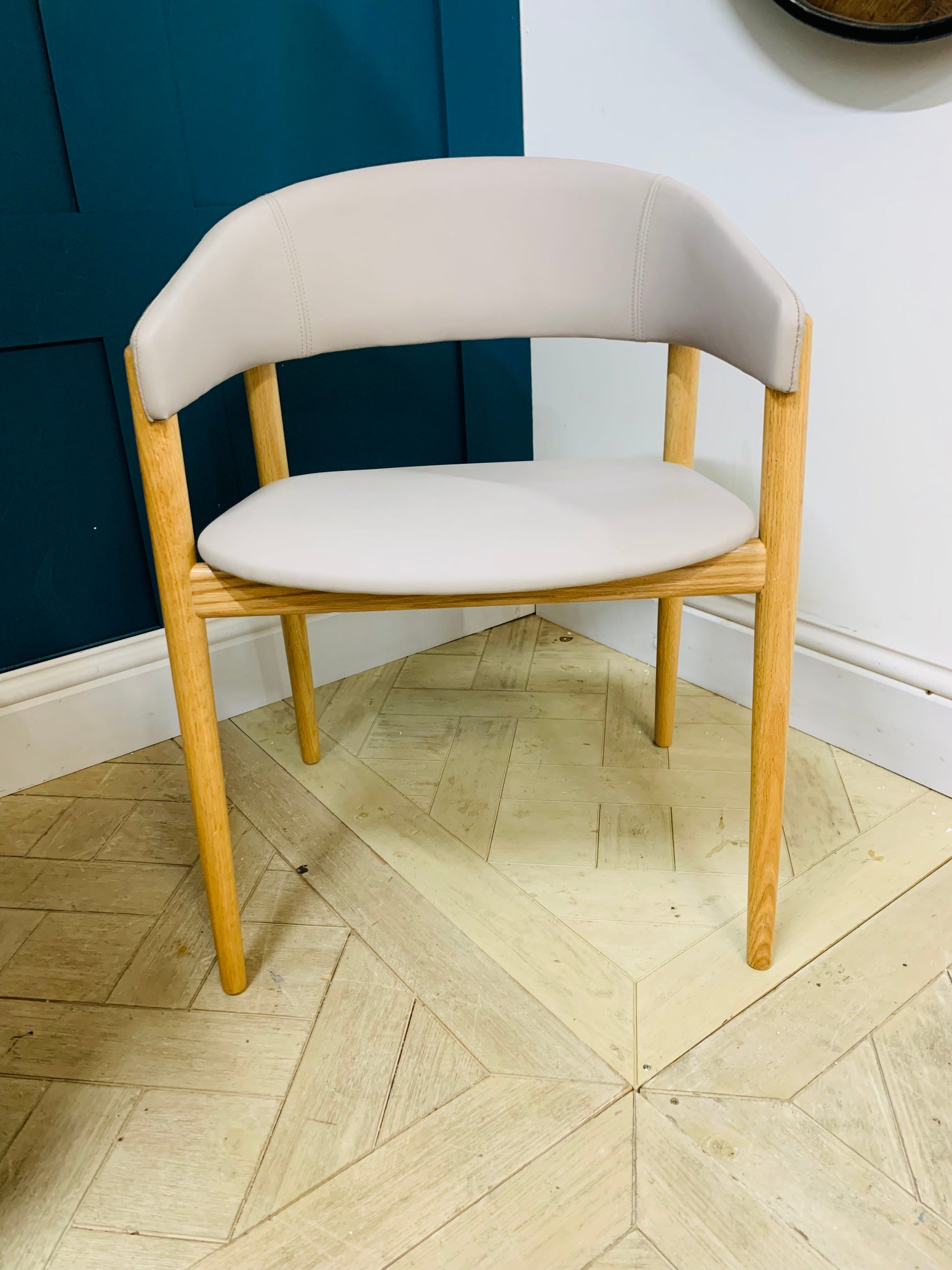 Contemporary dining armchair with a solid beechwood frame and soft, rounded upholstered backrest and seat