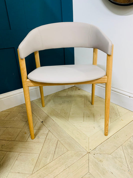 Contemporary dining armchair with a solid beechwood frame and soft, rounded upholstered backrest and seat