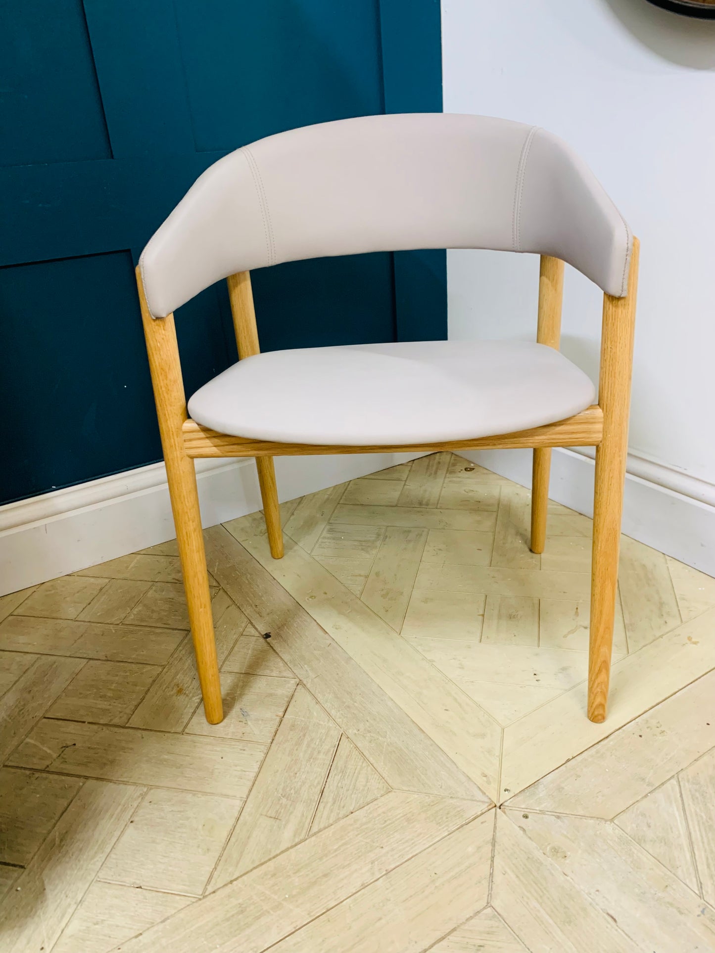 Contemporary dining armchair with a solid beechwood frame and soft, rounded upholstered backrest and seat