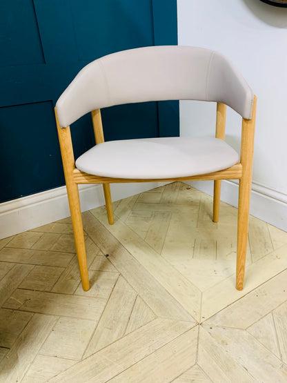 Contemporary dining armchair with a solid beechwood frame and soft, rounded upholstered backrest and seat