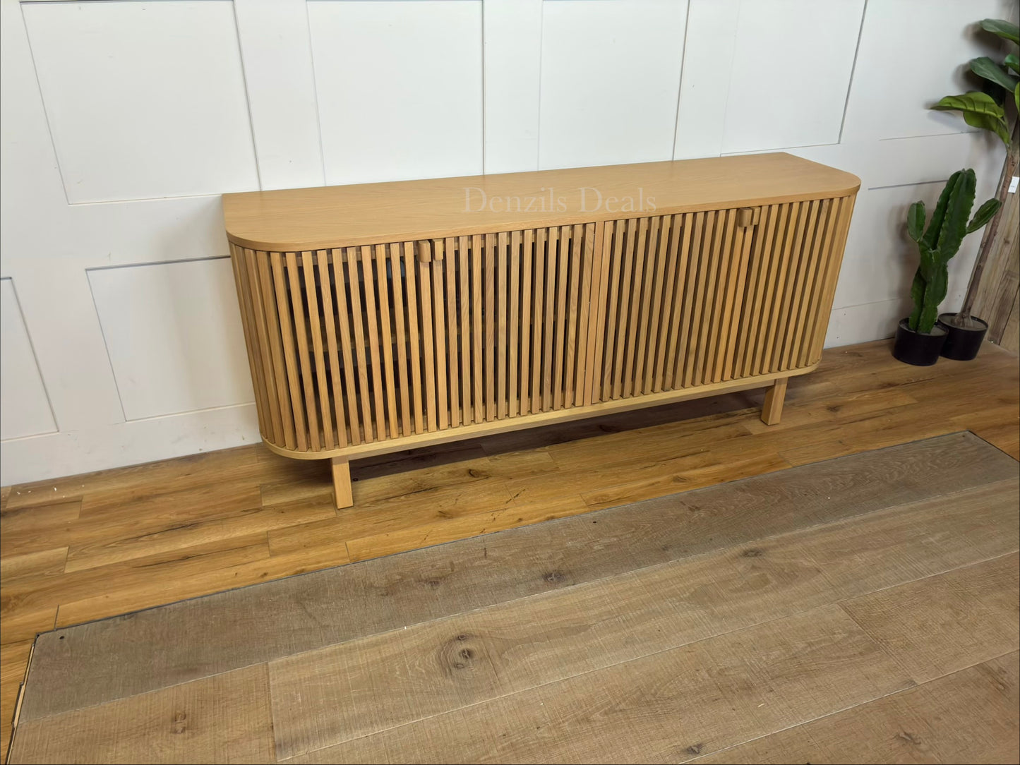 Curved oak sideboard and media unit by John Lewis featuring a vertical slatted wood front, closed storage cabinets, and natural light oak finish.