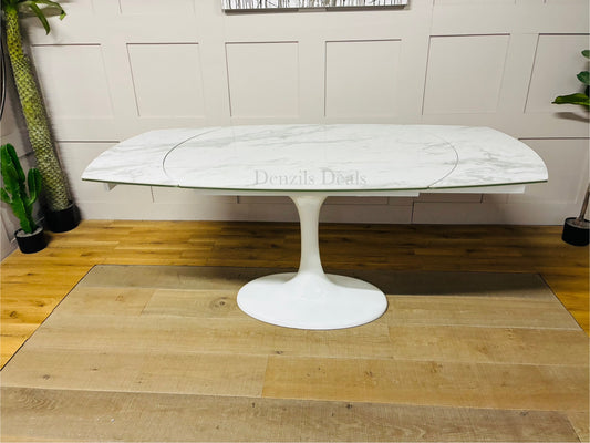 Overhead view of the DFS Lille white marble-effect dining table showing the rotating extension mechanism that expands seating from 4 to 6." 