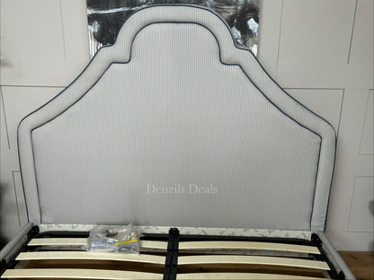 DFS Upholstered super king bed frame in a vibrant Joules hand-drawn blue ticking stripe  fabric with a dramatic tall headboard and sleek dark wood carved feet