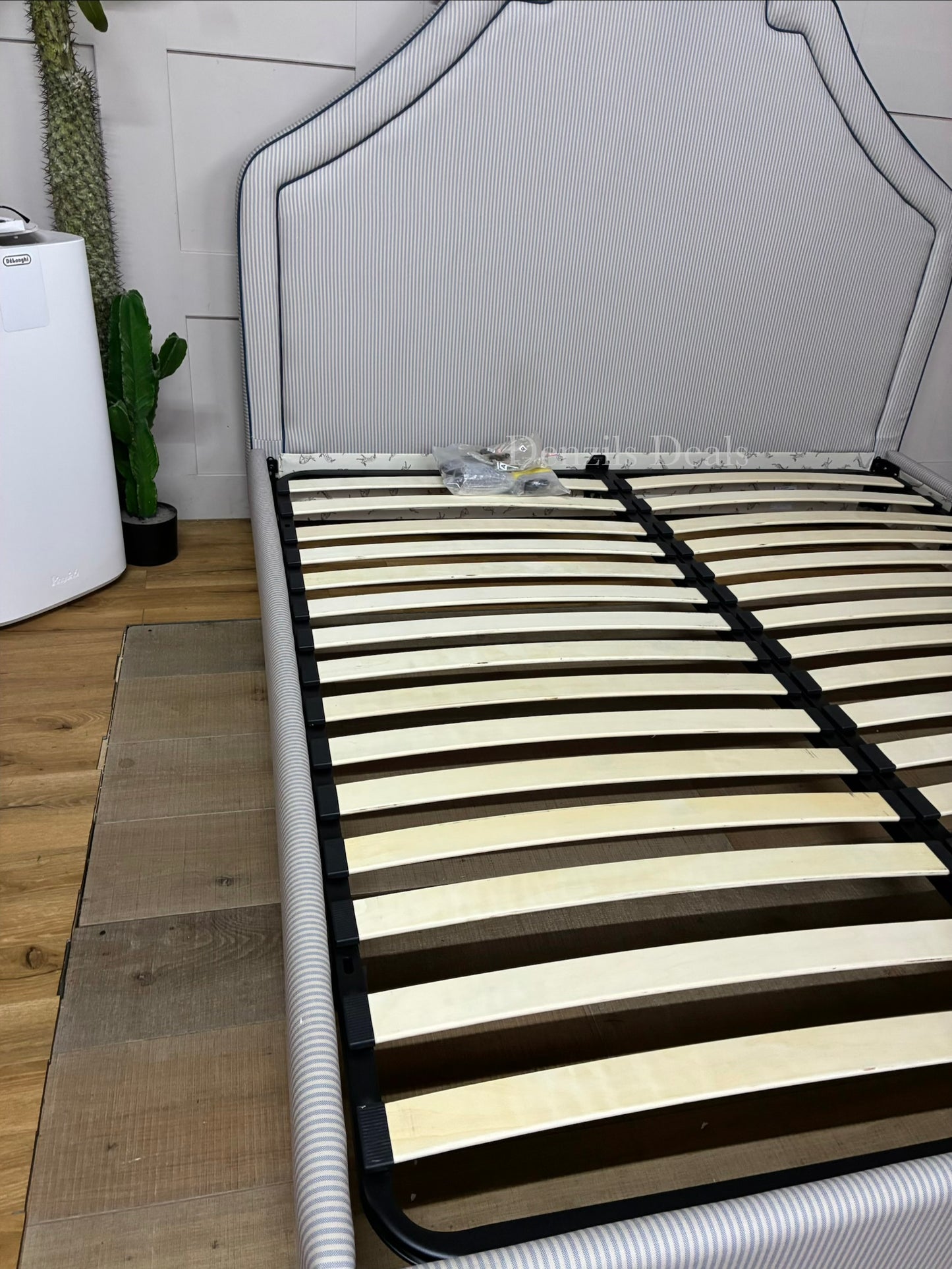 DFS Upholstered super king bed frame in a vibrant Joules hand-drawn blue ticking stripe  fabric with a dramatic tall headboard and sleek dark wood carved feet