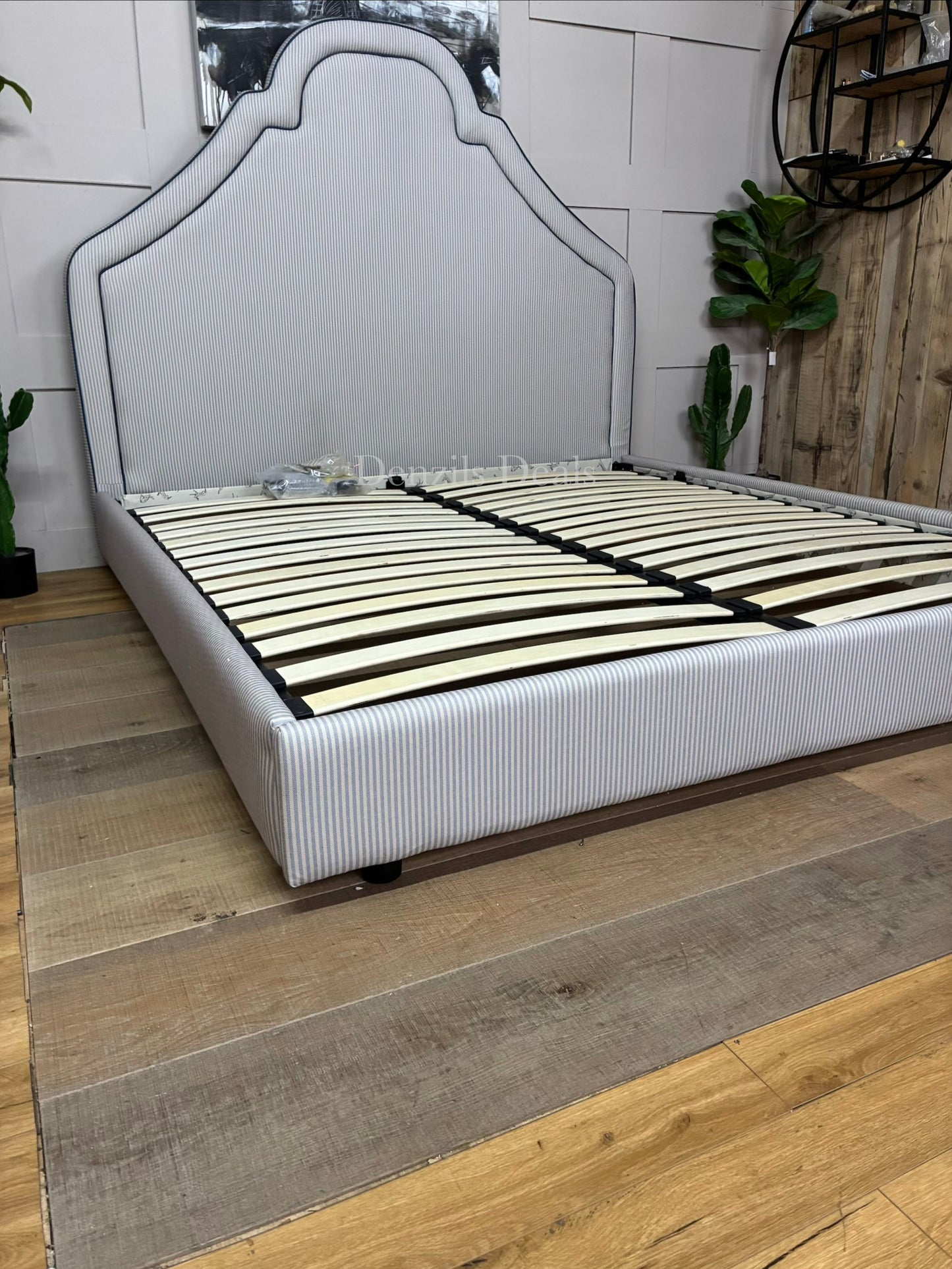 DFS Upholstered super king bed frame in a vibrant Joules hand-drawn blue ticking stripe  fabric with a dramatic tall headboard and sleek dark wood carved feet
