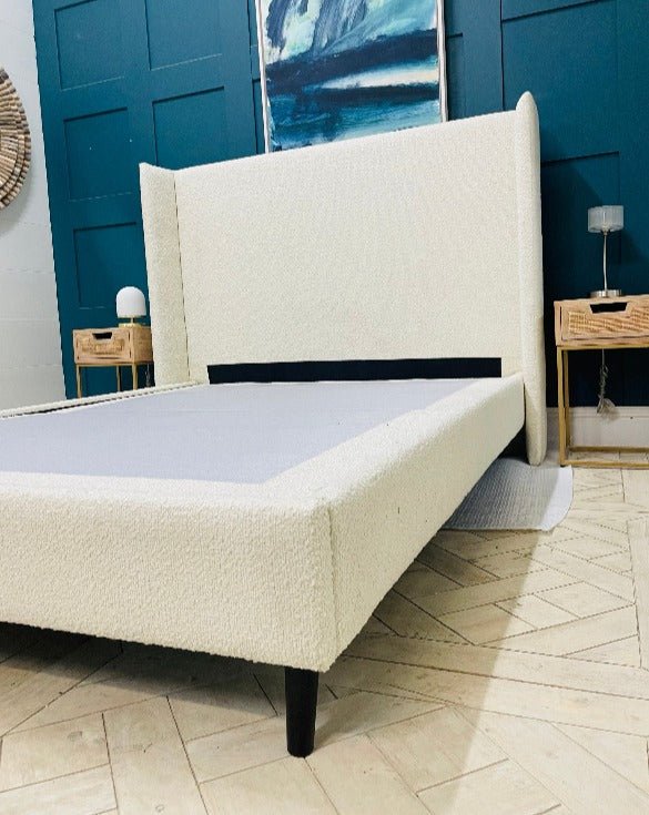 Doddington King Size Bed in Corto Ivory Bouclé fabric with a chic winged headboard and modern black feet.