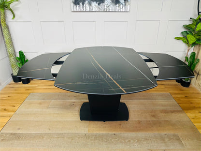 Dwell Tabula extending dining table shown in its unextended 150cm form, featuring a durable matte black ceramic tabletop with realistic marble veining, supported by a central black tulip base extends to 220cm