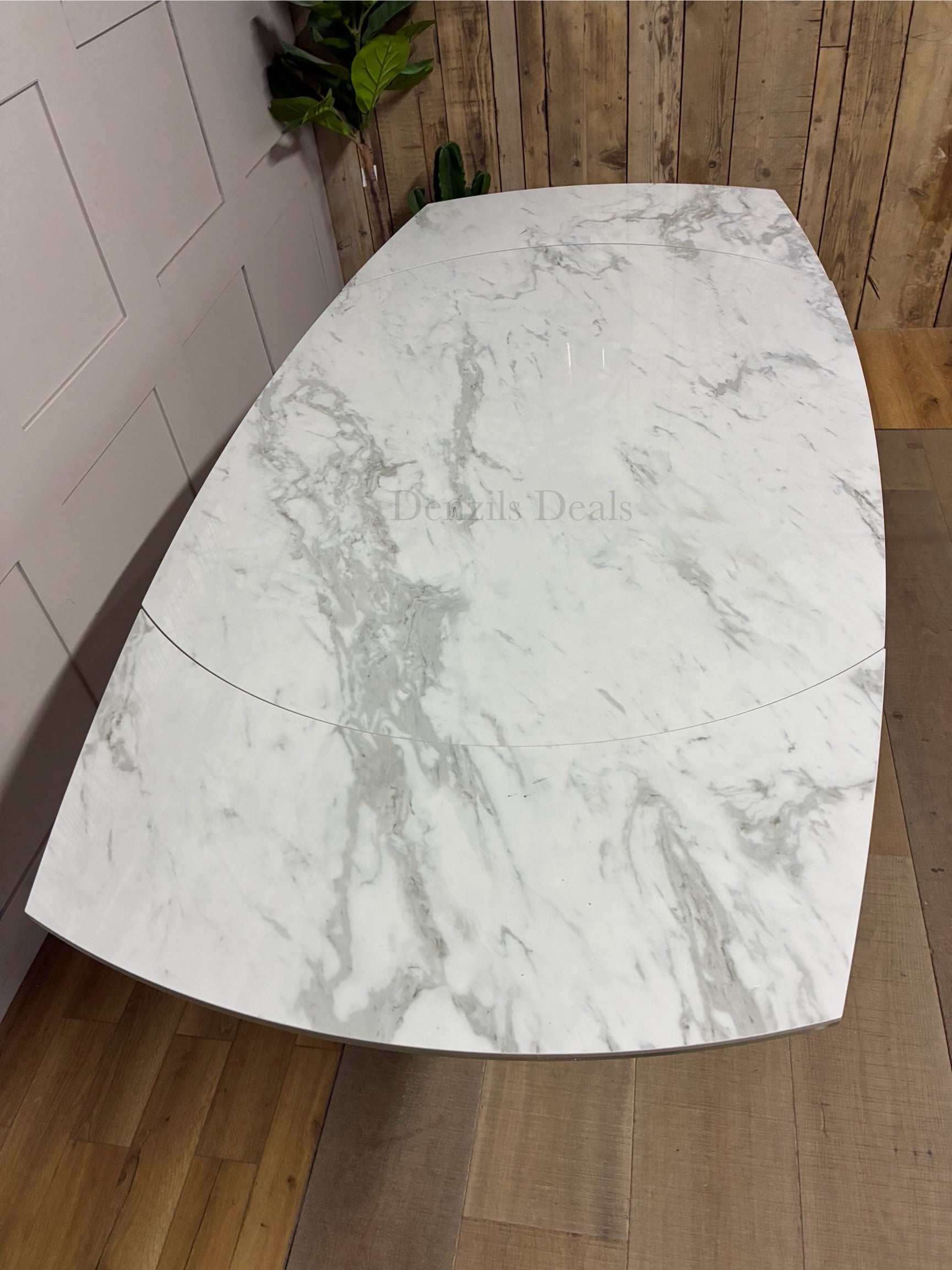 Overhead view of the DFS Lille white marble-effect dining table showing the rotating extension mechanism that expands seating from 4 to 6." 