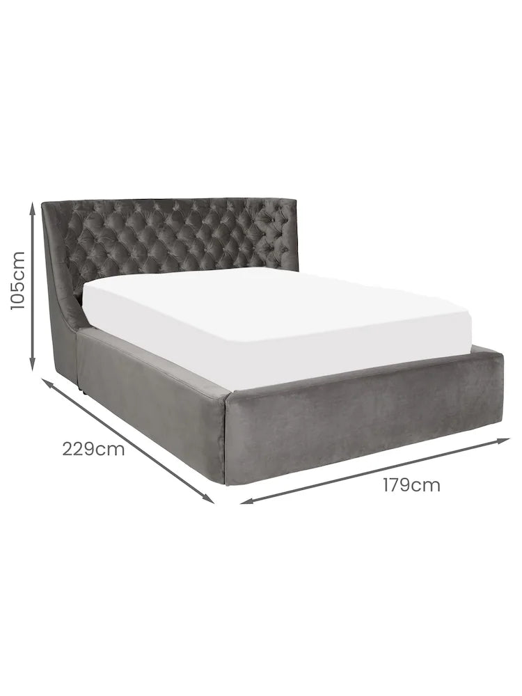 Elegant king size ottoman bed upholstered in grey fabric with a traditional buttoned headboard. Close up view on headboard 