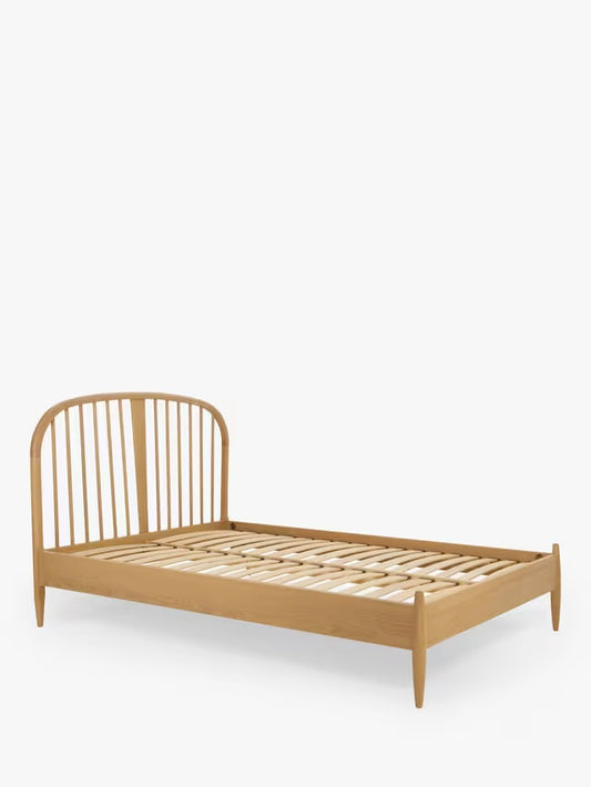 Ercol Hambledon double bed frame in oak, featuring a Scandi-inspired curved headboard with vertical solid wood spindles and a clear matte lacquer finish.