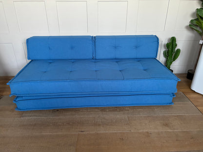 Fold-out Macy double sofa bed from Urban Outfitters upholstered in contemporary blue fabric."