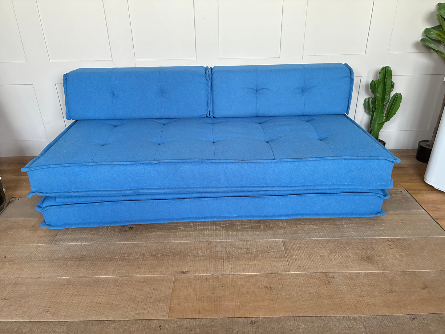 Fold-out Macy double sofa bed from Urban Outfitters upholstered in contemporary blue fabric."