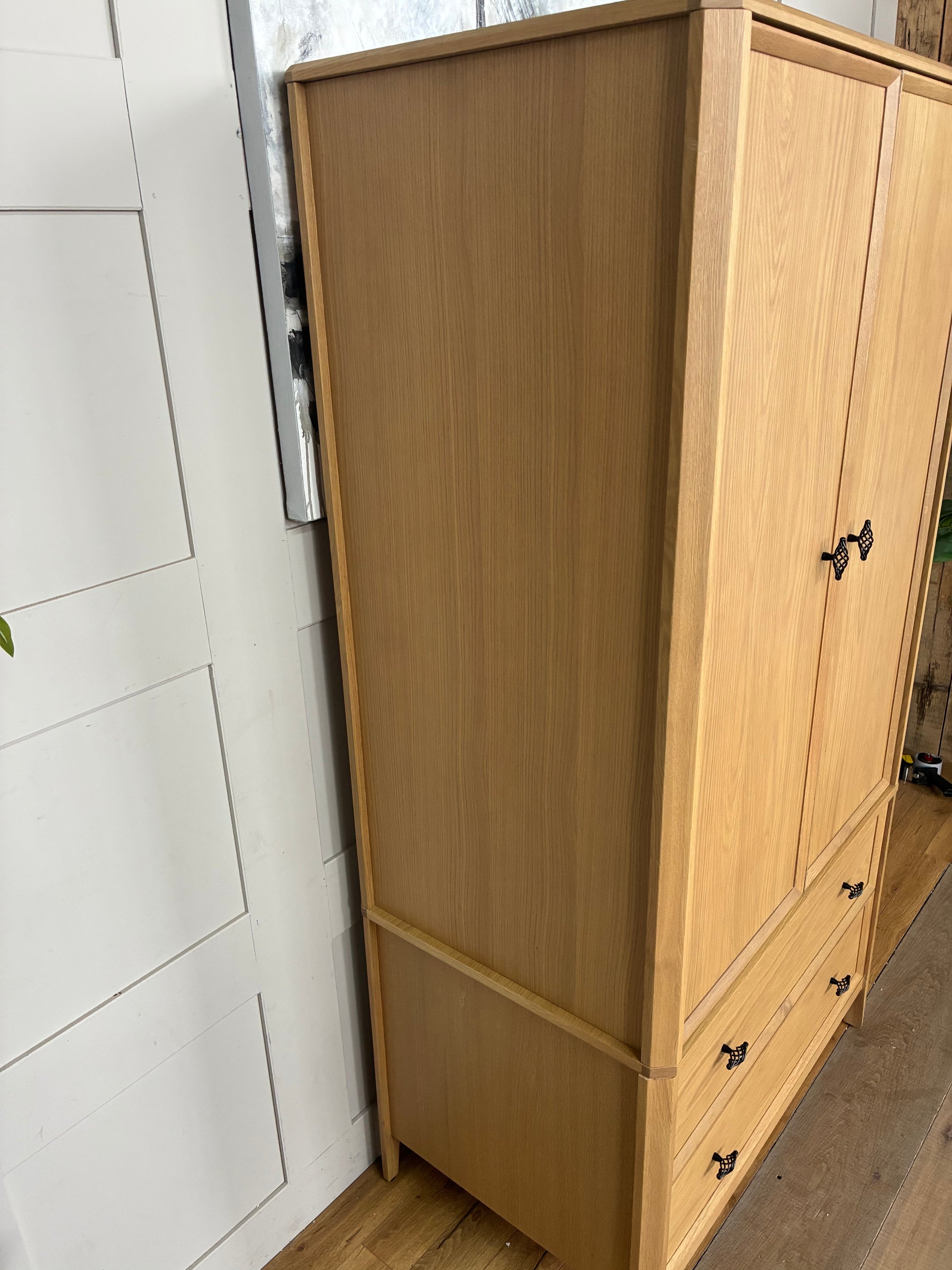 Freestanding John Lewis Bevel Double Wardrobe in a natural light oak finish, featuring two hinged doors with minimalist metal handles, two spacious storage drawers at the base, and distinctive beveled detailing along the edges and plinth.