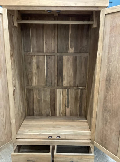 Freestanding Puji wardrobe crafted from solid natural teak wood. The piece features two large, hinged cabinet doors that open to full hanging space, set above three wide, horizontally aligned drawers at the base, and displays a prominent, rich grain finish."