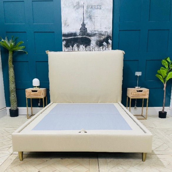 Gallery Direct Appledore double bed frame in a light grey upholstered fabric, featuring a minimalist rectangular headboard with external seam detailing and four tapered light-wood legs."