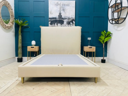 Gallery Direct Appledore double bed frame in a light grey upholstered fabric, featuring a minimalist rectangular headboard with external seam detailing and four tapered light-wood legs."