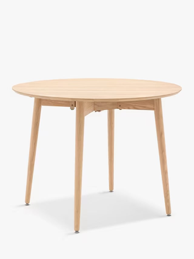 Gallery Direct Lewes folding dining table in natural oak with a round top and shaped wooden underframe