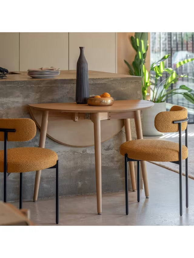 Gallery Direct Lewes round folding dining table in natural oak finish.
