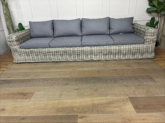 Gallery Direct Ragusa 3-seater garden sofa featuring a natural 9mm rounded weave poly-rattan finish, thick ivory showerproof cushions, and an aluminium frame on a sunny patio