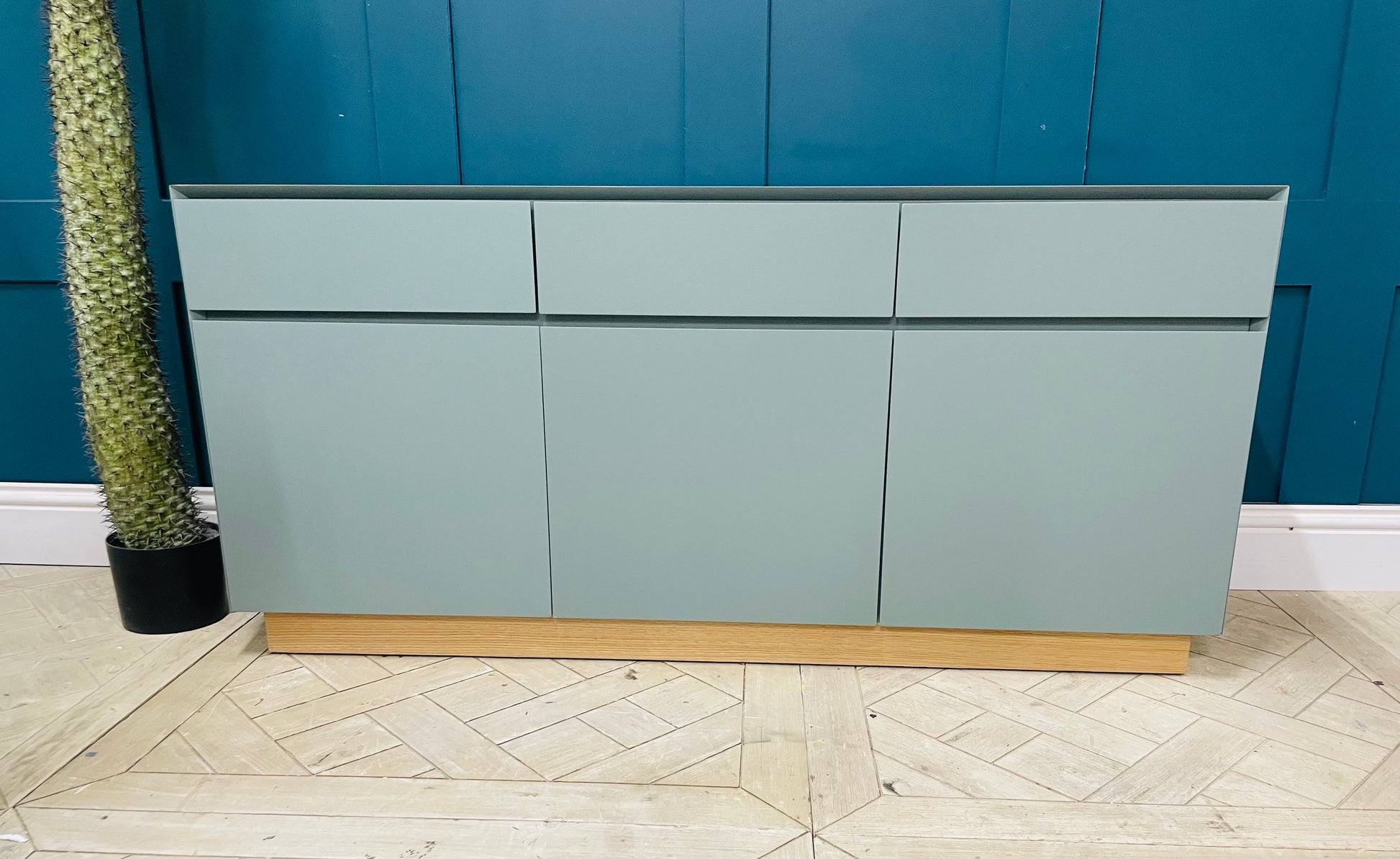 Green MADE.com Elsdon large sideboard providing elegant storage for a modern living room