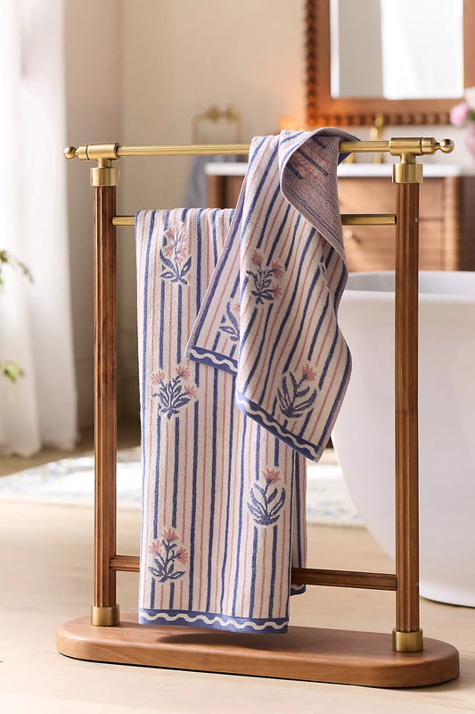Hand-carved acacia wood towel stand with a polished brass holder, featuring a distinctive ribbed wooden base and stainless steel hardware
