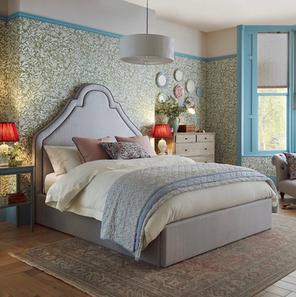 Handmade Joules Thornton super king bed frame in blue, featuring a towering oversized headboard, classic turned dark-wood feet, and all-over heritage upholstery