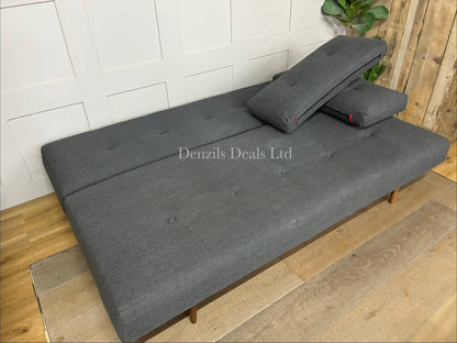 Innovation Living Recast sofa bed featuring a button-tufted fabric design, loose back cushions, and tapered dark wood legs.
