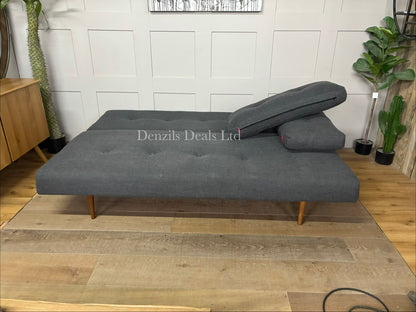 Innovation Living Recast sofa bed featuring a button-tufted fabric design, loose back cushions, and tapered dark wood legs.