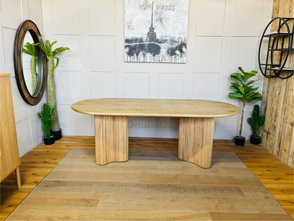 Interior shot of the Anthropologie Scout dining table, crafted from blond ash wood with an organic woodgrain veneer top and whimsical, curved fluted legs