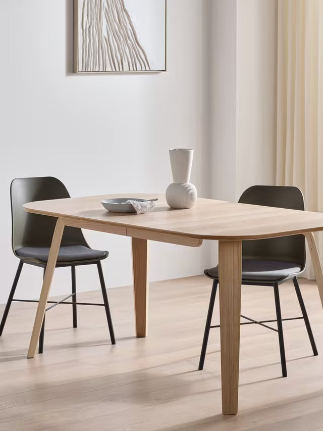 John Lewis ANYDAY Anton 6-8 seater extending dining table in light oak, featuring a curved rectangular top and four tapered wooden legs on a plain background.